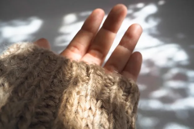 A detailed shot of a hand gently touching a knitted alpaca scarf. The focus is on the texture of the material, highlighting its softness and natural sheen. The hand is well-manicured and the lighting emphasizes the warmth and comfort associated with the scarf.