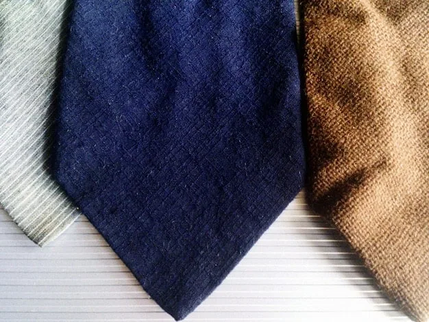 A close-up shot of various fabric textures used for layering, including cashmere, denim, cotton, and wool. The image emphasizes the importance of selecting comfortable and breathable materials for transitional dressing.