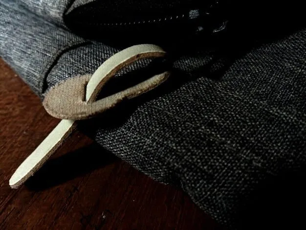 Close-up of a textured, neutral-toned blazer hanging on a wooden hanger. The blazer is made of a high-quality linen blend and has a modern, slightly oversized cut. The background is a blurred, minimalist closet with other coordinating separates.