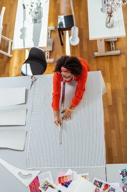 A designer in their studio, surrounded by fabric samples and sketches, working on a new menswear piece. The atmosphere is creative and focused, showing the intersection of traditional techniques and innovative materials.