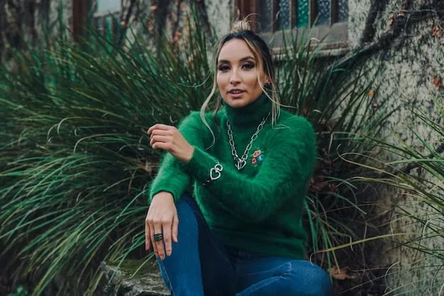 A model with a warm skin tone wearing various outfits in olive green, mustard yellow, and a brick red dress. The outfits are styled with gold accessories to further enhance the warm tones. The background is a blurred outdoor setting.