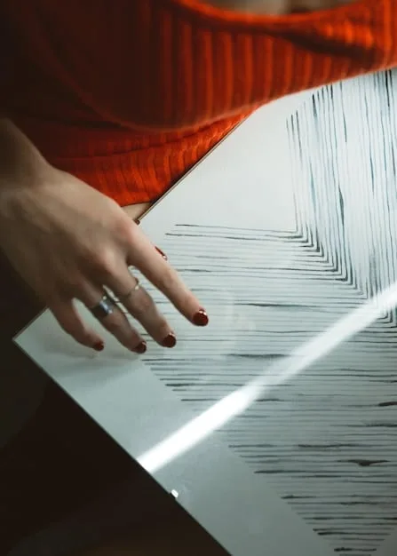 A close-up shot of a designer's hands sketching a couture gown design in a sketchbook. The sketch shows intricate lace details and flowing lines, capturing the initial creative vision.