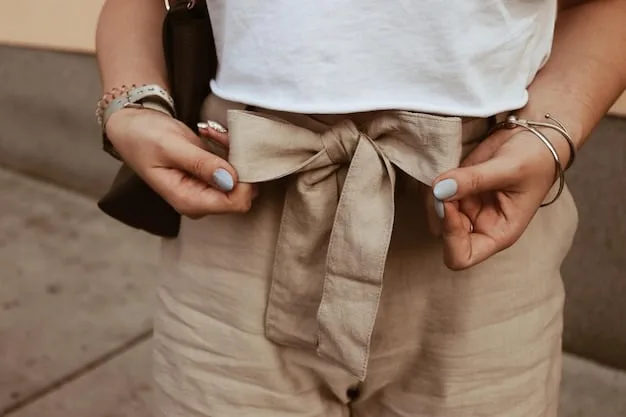 A close-up shot of a woman's hands accessorizing a neutral outfit. She is adding a colorful scarf to a beige trench coat, with a stack of bangles on her wrist. The background is softly blurred, showcasing a rack of neutral-colored clothing, emphasizing the versatility of a neutral-based wardrobe. The lighting is soft and diffused, focusing on the textures of the scarf and coat.
