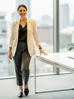 Professional woman in modern office, wearing versatile capsule wardrobe
