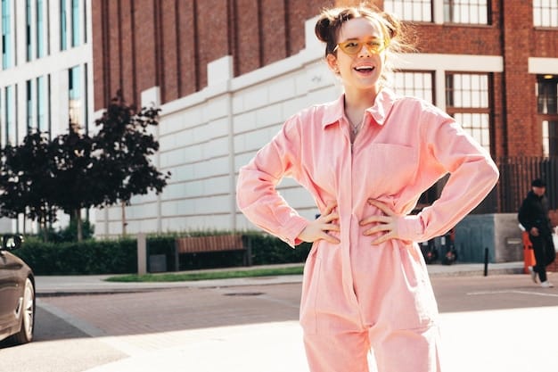 A street style photograph featuring a woman with an hourglass figure wearing high-waisted, tailored pastel lavender pants paired with a white crop top and nude heels. She is accessorized with a delicate gold necklace and a small clutch. The background is a bustling city street.
