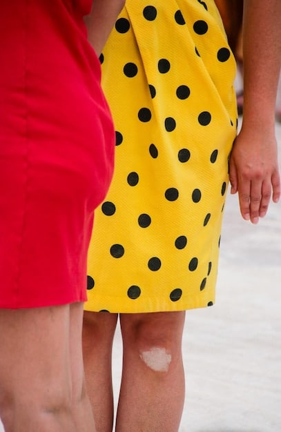 Close-up of two different prints being combined in an outfit: a small polka dot shirt paired with a larger floral print skirt, focusing on the harmonious color scheme and contrast in scale.
