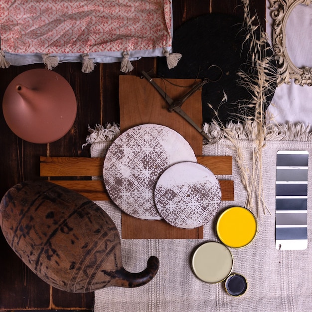 A collection of home decor items in muted terracotta, including ceramics, textiles, and wall paint samples.