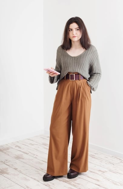 A woman wearing wide-leg pants with a tucked-in blouse and a stylish belt, showcasing how to define the waist.