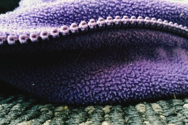 A close-up shot of various fabric textures used in layering, including merino wool, fleece, and waterproof nylon. The image highlights the different properties and functionalities of each fabric.