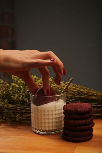 Close-up shot of a woman's hands adjusting a large, geometric cocktail ring on her finger, with a blurred background of a chic, modern office space.