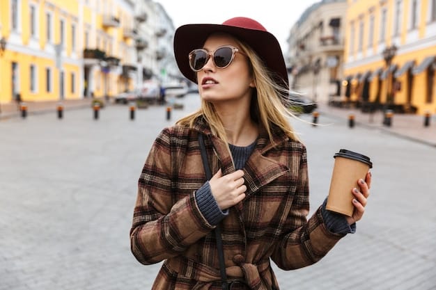 A stylish woman wearing a wide-brimmed hat and oversized sunglasses, standing on a bustling city street with a coffee in hand.