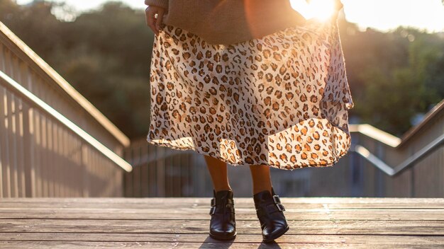A fashion blogger showcasing an outfit with a tan and black leopard print skirt paired with a black and white striped top. The overall effect is stylish and balanced, with the neutral stripes complementing the bolder leopard print.