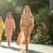 Models on a runway presenting new summer fashion collection with bright colors and light fabrics.
