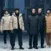 Models displaying stylish and warm winter 2026 outerwear in a snowy city scene.