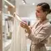 Woman inspecting high-quality fabric carefully in a modern store setting.