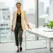 Professional woman in modern office, wearing versatile capsule wardrobe
